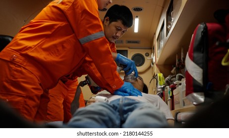 Asian emergency medical technician (EMT) or paramedic team heart pumping CPR the patient, Sudden cardiac arrest or Cardiopulmonary resuscitation concept - Powered by Shutterstock