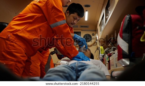 Asian emergency medical technician\
(EMT) or paramedic team heart pumping CPR the patient, Sudden\
cardiac arrest or Cardiopulmonary resuscitation\
concept