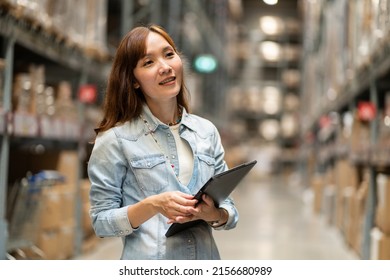 Asian Employee Holding A Tablet Works In The Procurement Department, Checking Inventory In The Warehouse To Order Goods Into The Warehouse.