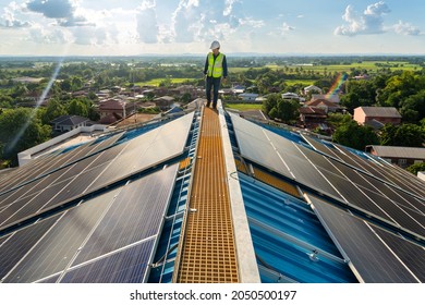 Asian Engineer Checking Equipment In Solar Power Plant On Roof. Clean Energy