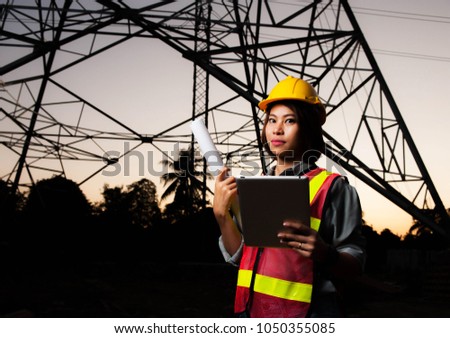 Asian engineer girl holding blueprint and tablet at construcktion site on twilight background,Asian women engineer portrait,lowkey picture