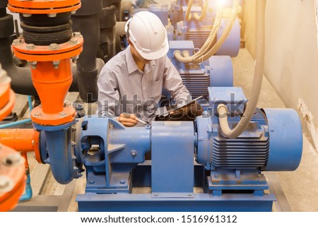 Asian engineer maintenance checking technical data of  system equipment Condenser Water pump and pressure gauge ,  water pump.