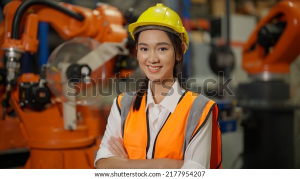 Asian engineer portrait, Confident female\
industrial engineer specialist safety uniform protection crossing\
arms smiling to camera, Engineer portrait concept. Asian Female\
manager engineer concept.