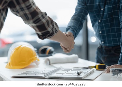 Asian engineer team and architects working designing planing of project, Engineer handshake, Home renovation concept.   - Powered by Shutterstock