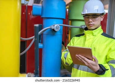 Asian Engineer Wearing Glasses Working In The Boiler Room,maintenance Checking Technical Data Of Heating System Equipment,Thailand People