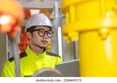 Asian Engineer Wearing Glasses Working In The Boiler Room,maintenance Checking Technical Data Of Heating System Equipment,Thailand People