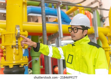 Asian Engineer Wearing Glasses Working In The Boiler Room,maintenance Checking Technical Data Of Heating System Equipment,Thailand People