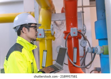 Asian Engineer Wearing Glasses Working In The Boiler Room,maintenance Checking Technical Data Of Heating System Equipment,Thailand People