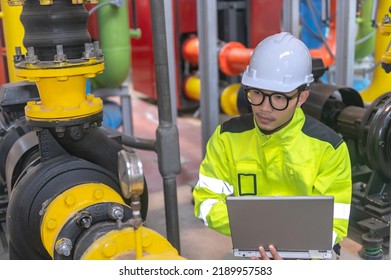 Asian Engineer Wearing Glasses Working In The Boiler Room,maintenance Checking Technical Data Of Heating System Equipment,Thailand People