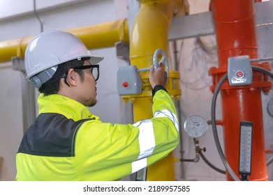 Asian Engineer Wearing Glasses Working In The Boiler Room,maintenance Checking Technical Data Of Heating System Equipment,Thailand People