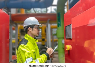 Asian Engineer Wearing Glasses Working In The Boiler Room,maintenance Checking Technical Data Of Heating System Equipment,Thailand People