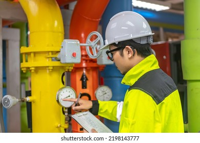 Asian Engineer Wearing Glasses Working In The Boiler Room,maintenance Checking Technical Data Of Heating System Equipment,Thailand People