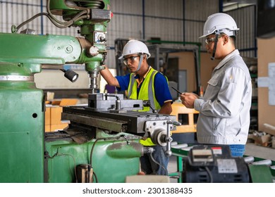 Asian engineer and worker operating lathe grinding machine - metalworking industry concept. Mechanical Engineering control lathe machine in factory. - Powered by Shutterstock