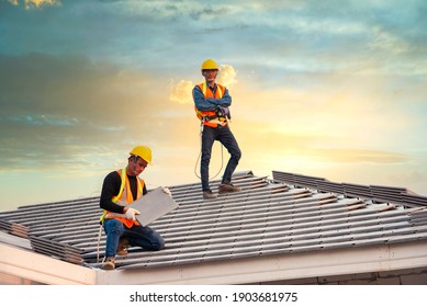 Asian engineer workers install new CPAC roof, roofing tools, electric drill, use on new roof with CPAC roof house construction idea.