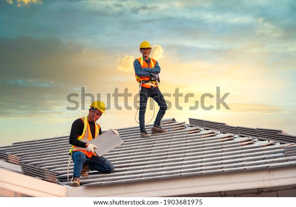 Asian engineer workers install new CPAC roof,\
roofing tools, electric drill, use on new roof with CPAC roof house\
construction idea.