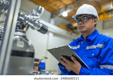 Asian engineer working at Operating hall,Thailand people wear helmet  work,He worked with diligence and patience,she checked the valve regulator at the hydrogen tank. - Powered by Shutterstock