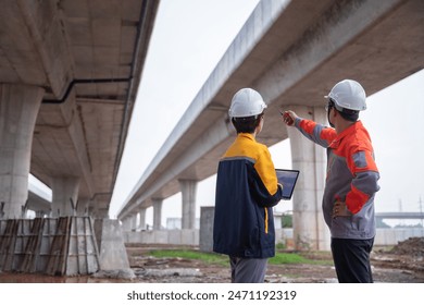 Asian engineering team conducting an inspection at a highway construction site, evaluating the quality of the concrete road and ensuring compliance with standards. - Powered by Shutterstock