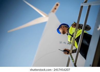 Asian engineers working in fieldwork outdoor. Workers check and inspect construction and machine around building project site. Wind turbine for electrical of clean energy and environment sustainable. - Powered by Shutterstock