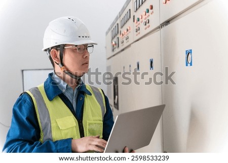 Asian engineers are working in the power distribution room.