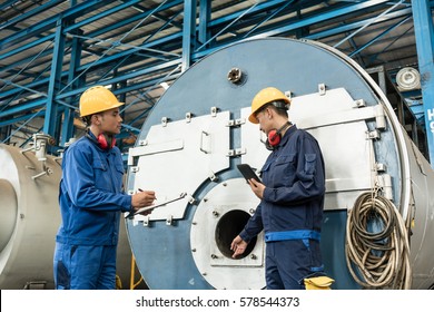Asian expert checking the quality requirements of manufactured industrial steam boilers