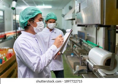 Asian factory workers were checking list with chart to safety policy on automatic machine in beverage industry before start process - Powered by Shutterstock