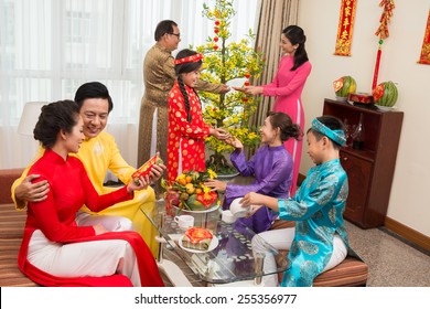 Asian Family In Ao Dai Dresses Celebrating Tet At Home