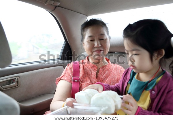 The Asian family in\
the back seat of car.