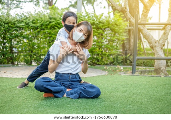 asian-family-boy-wear-face-mask-hug-his-mother-from-back-at-home-garden