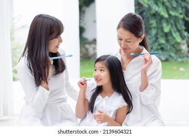 Asian Family Brushing Their Teeth