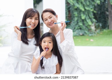 Asian Family Brushing Their Teeth