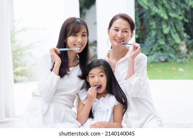 Asian Family Brushing Their Teeth