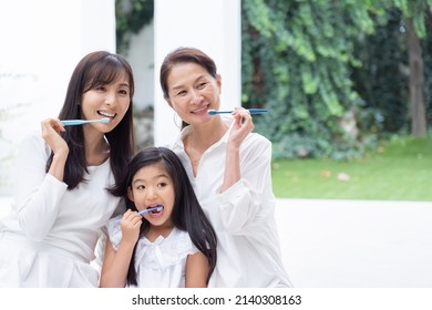 Asian Family Brushing Their Teeth