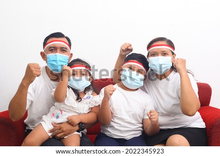 Asian family celebrate Indonesia's independence day during the pandemic. They wearing a face mask. Isolated on white background