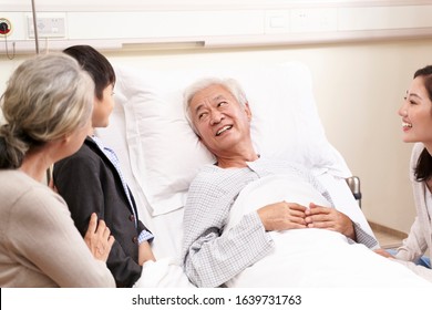 asian family with child mother and grandmother visiting grandfather in hospital