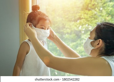 Asian Family With Children In Face Mask, Mother Prepare To Put Face Mask On Her Kid Before Leaving House To Go School For Prevent Germs During The Coronavirus Or Covid-19 Outbreak. New Normal Concept