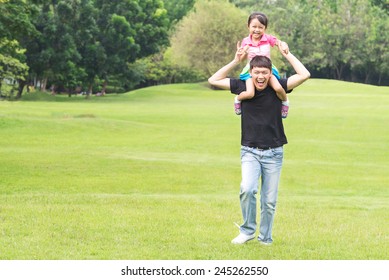 Asian Family Concept - Father Giving Daughter Piggyback Ride