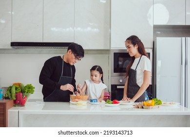 Asian Family Cooking At Home. Happy Family Cooks Together In The Kitchen Home Recreation And Weekend Meal Prep.