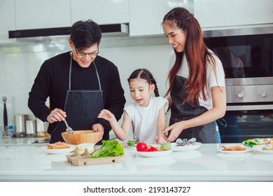 Asian Family Cooking At Home. Happy Family Cooks Together In The Kitchen Home Recreation And Weekend Meal Prep.