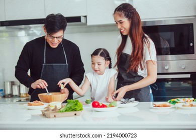 Asian Family Cooking At Home. Happy Family Cooks Together In The Kitchen Home Recreation And Weekend Meal Prep.