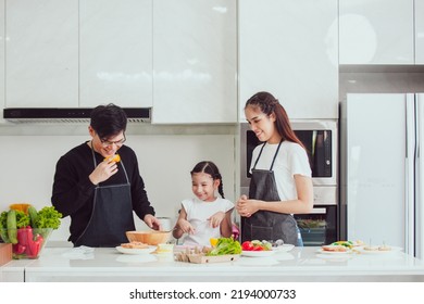 Asian Family Cooking At Home. Happy Family Cooks Together In The Kitchen Home Recreation And Weekend Meal Prep.