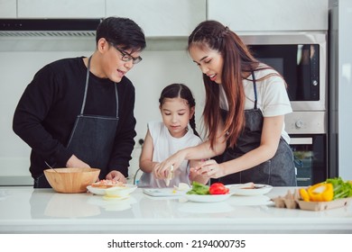 Asian Family Cooking At Home. Happy Family Cooks Together In The Kitchen Home Recreation And Weekend Meal Prep.