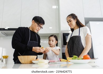 Asian Family Cooking At Home. Happy Family Cooks Together In The Kitchen Home Recreation And Weekend Meal Prep.