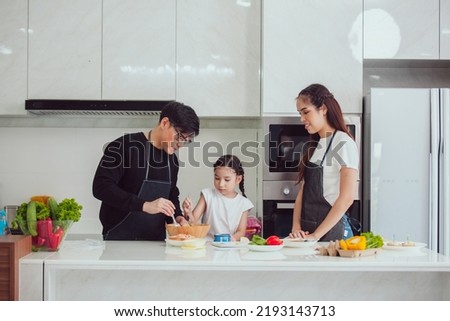Asian family cooking at home. Happy family cooks together in the kitchen home recreation and weekend meal prep. Foto stock © 