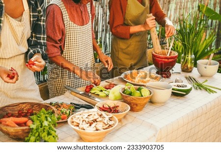 Asian family cooking thai food dinner together while preparing papaya salad at home backyard outdoor - Ethnic meal concept - Main focus on center woman hand