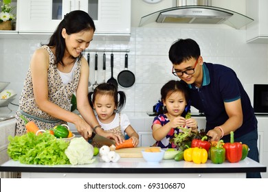 Asian Family Cooking Together In Kitchen
