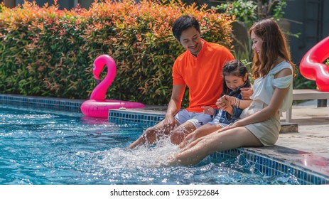 Asian Family Dad Mom And Kid Having Fun Together Playing By Swimming Pool In Resort And Hotel On Summer Vacation