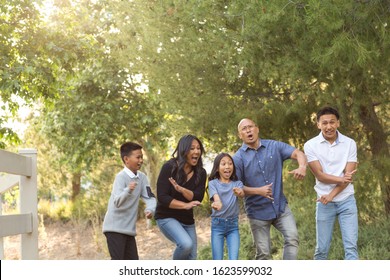 Asian family dancing and being playful.