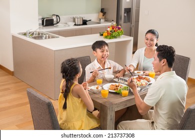 Asian Family Dining Together In The Kitchen