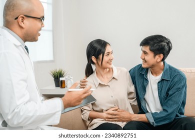 Asian family discussing fertility with a pediatrician. Young couple patients in fertility clinic consulting about IVF or IUI with doctor. Couple relationship therapy with a counselor - Powered by Shutterstock