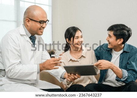 Asian family discussing fertility with a pediatrician. Young couple patients in fertility clinic consulting about IVF or IUI with doctor. Couple relationship therapy with a counselor
